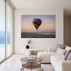 Carried by Light, a colorful hot air balloon photograph at sunrise, displayed as large-scale wall art in a serene contemporary living room.