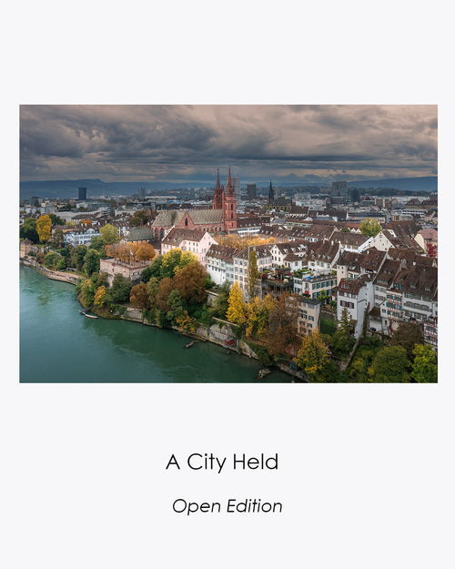 Aerial view of Basel, Switzerland, with the Basler Münster, historic rooftops and autumn trees beside the Rhine.