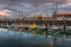 Boats and their reflections glowing in the blue-hour stillness of San Francisco as the last light of night begins to fade.