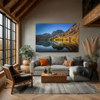 Autumn Echo displayed above a gray sectional sofa in a living room with exposed wood beams, tall windows, and warm autumn accents.