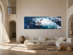 Large-scale Confluence panoramic ocean photograph displayed above a white sofa in a warm contemporary living room with a resting dog.